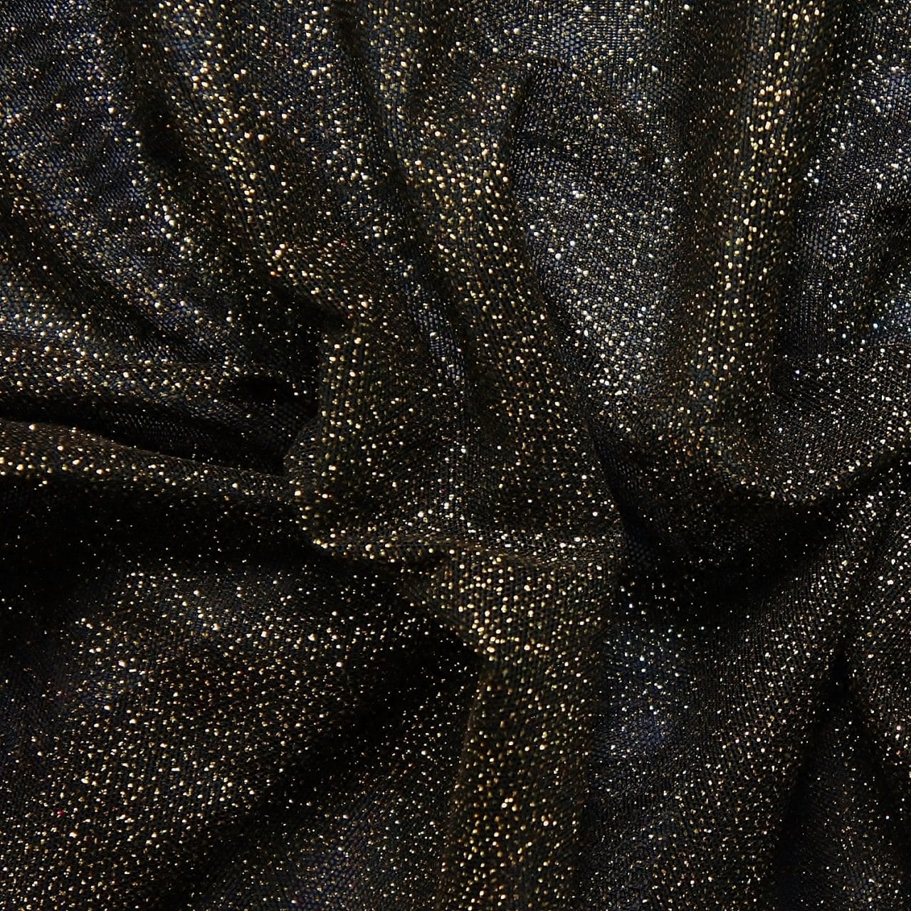 Black Gold Glitter Mesh fabric features all over gold glitter on 2-way stretch black polyester mesh making it ideal for both semi-fitted and draped garments.